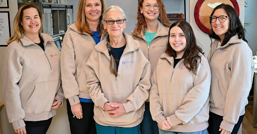The Full Circle Function team — six dedicated practitioners in matching tan jackets at their Wood River, Illinois clinic